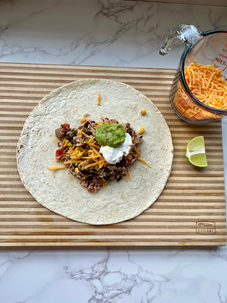 Southwest burritos ready to be wrapped up with the filling, guac, sour cream, and cheese