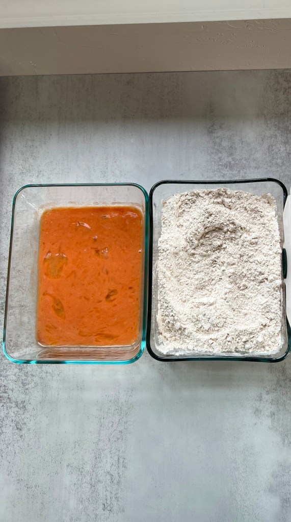 A breading station set up for some chicken breasts