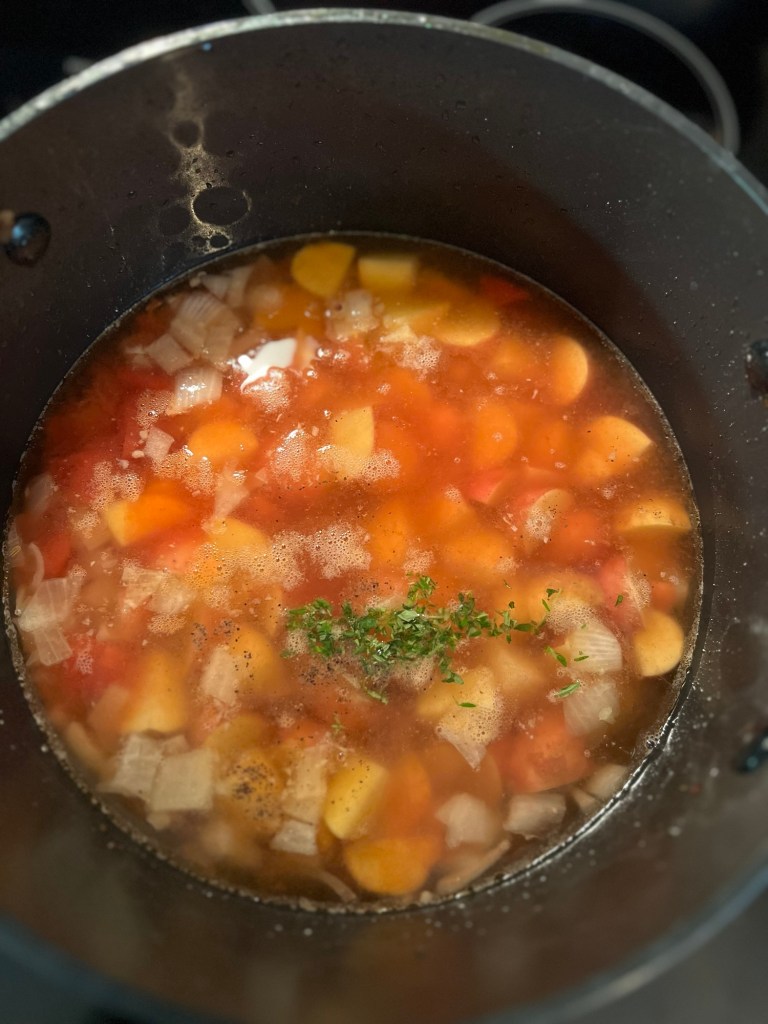 A large pot filled with soup on the stove
