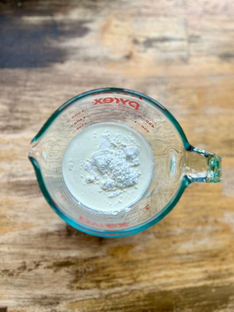 Heavy cream and cornstarch in a measuring cup