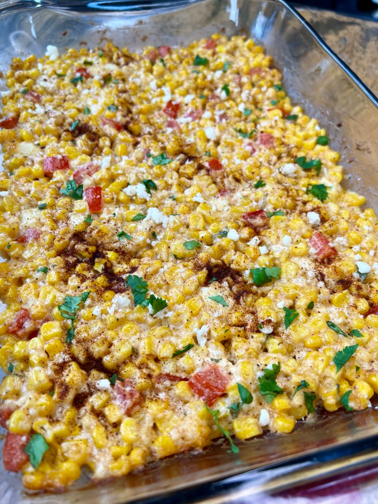Street corn casserole in a baking dish on a wooden table