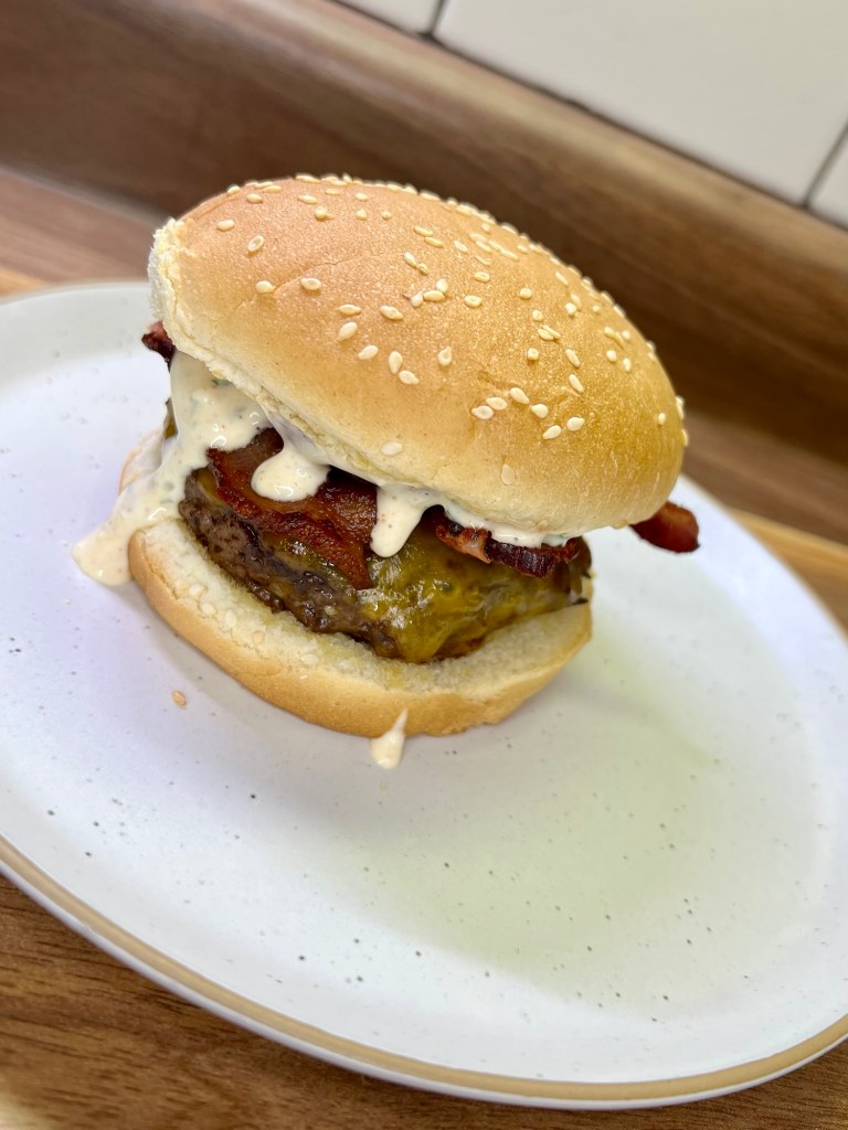 Cheeseburgers on a white plate on a wooden countertop