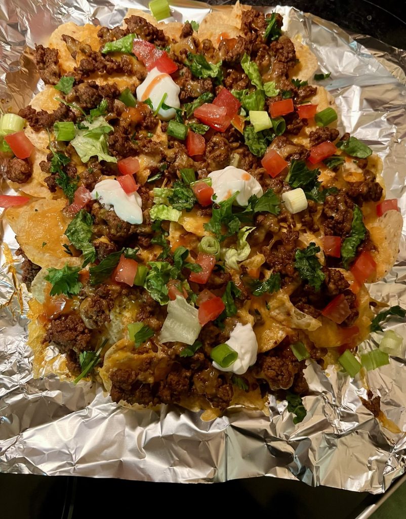 Air fryer nachos with garnishes on top, laid out to show everything