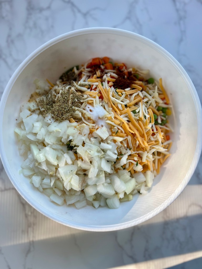 A bowl filled with the filling for chicken noodle casserole on a marble counter