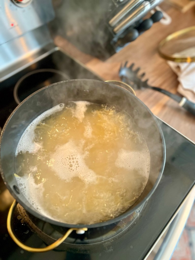 A large pot with spaghetti boiling in it