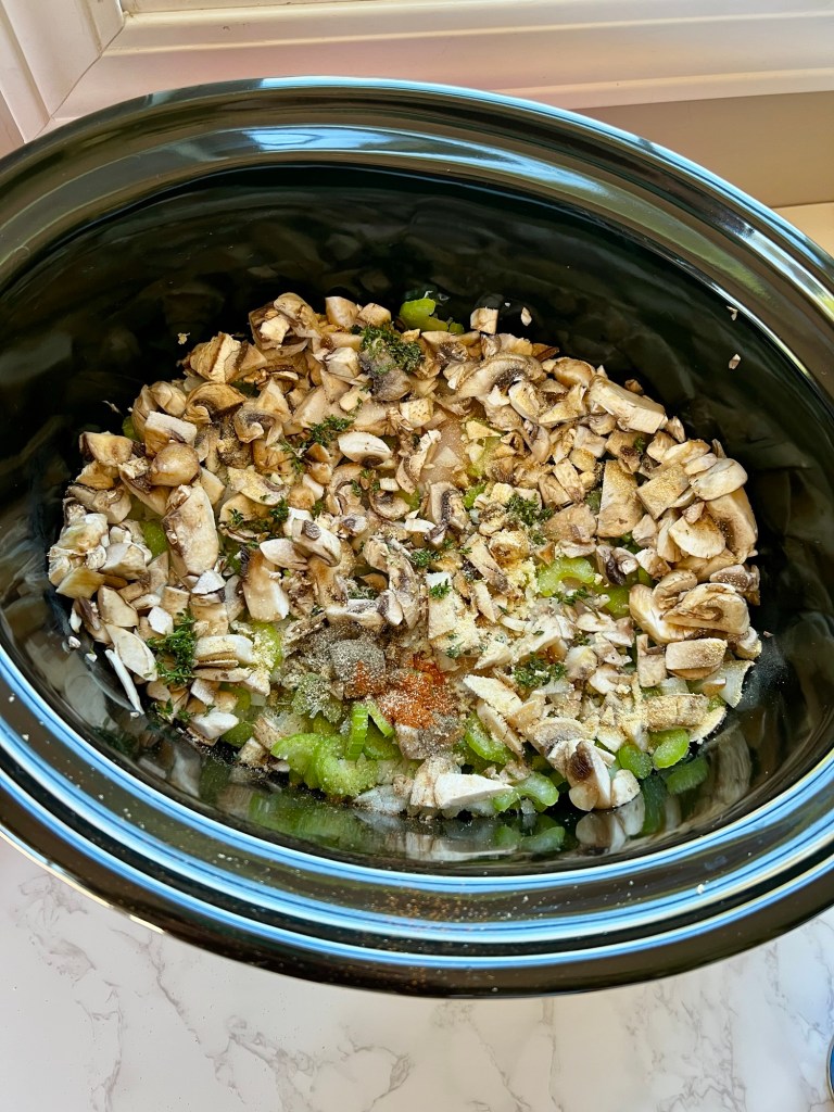All the ingredients to make creamy chicken and rice soup in a crockpot on a marble countertop