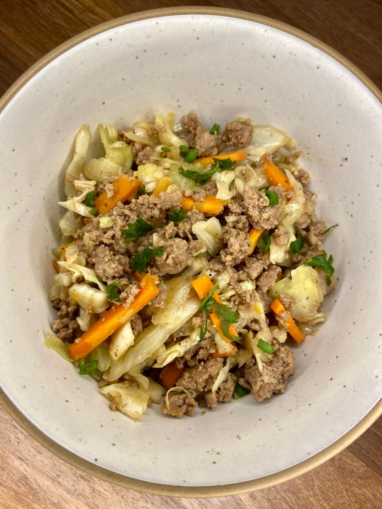Egg roll bowl in a white bowl on a wooden counter