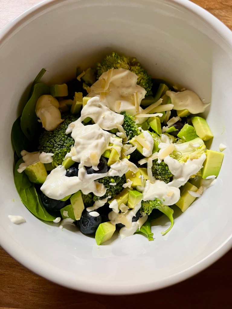 Avocado blueberry broccoli salad with creamy garlic dressing in a large bowl