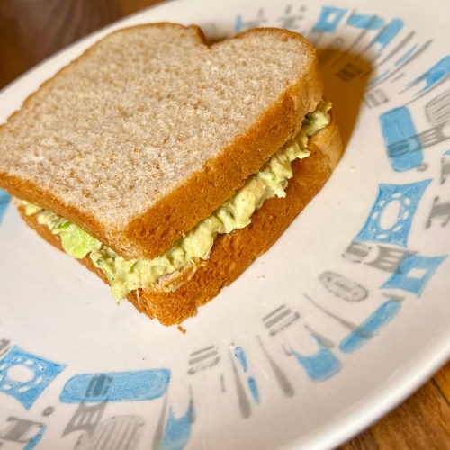 Avocado chicken salad on bread on a white plate