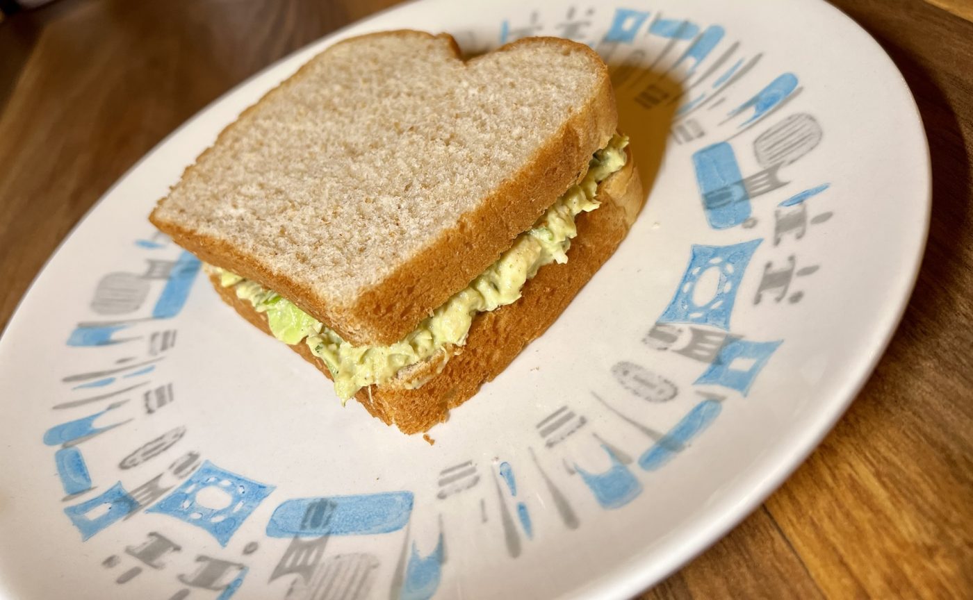 Avocado chicken salad on bread on a white plate