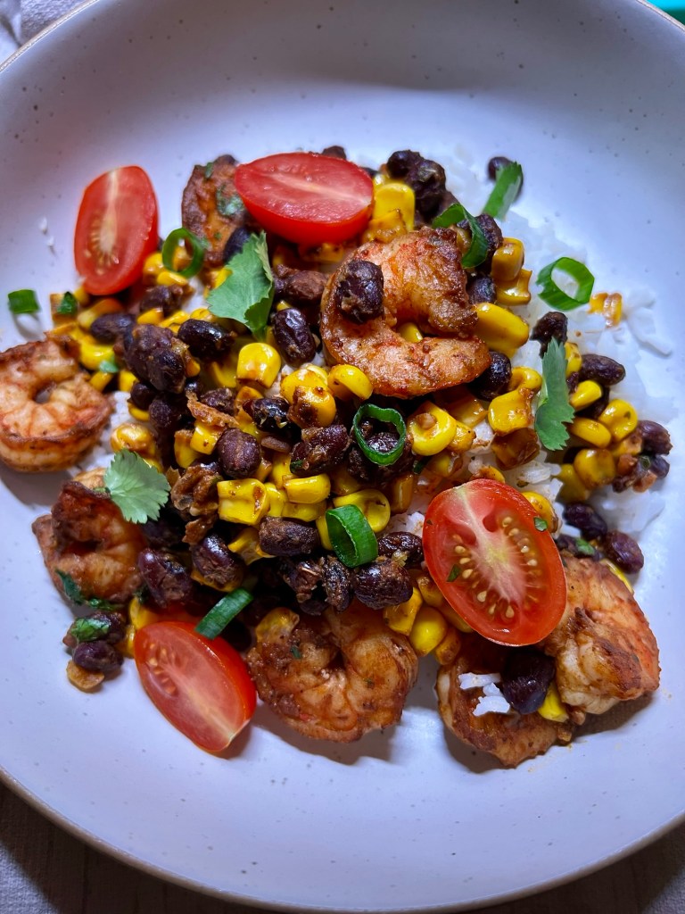 Shrimp bowl over a bed of cilantro lime rice in a white bowl on a countertop