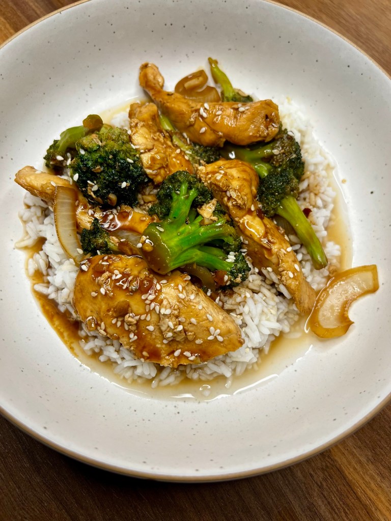 Chinese Chicken and Broccoli over some rice in a white bowl