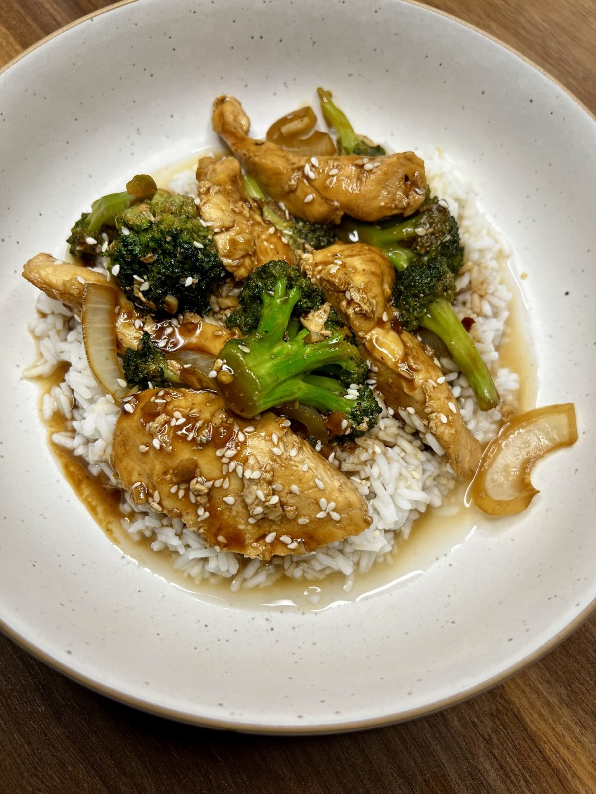 Chinese Chicken and Broccoli over some rice in a white bowl