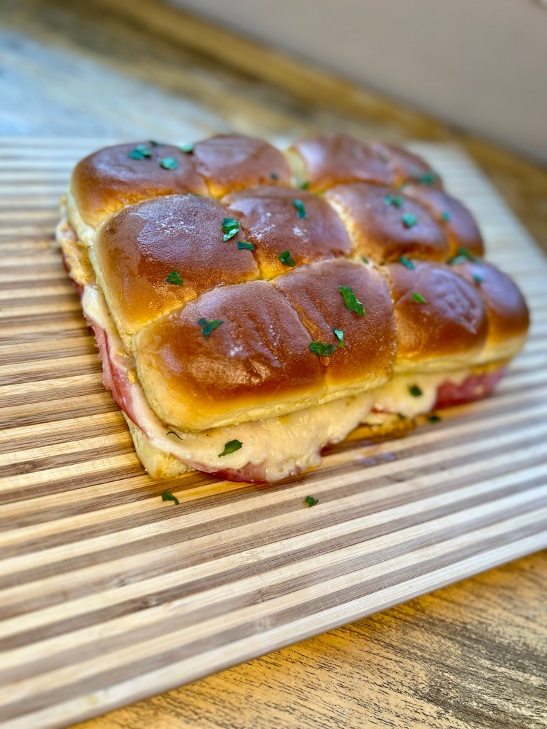 Cubano inspired sliders on a wood cutting board on a wood table