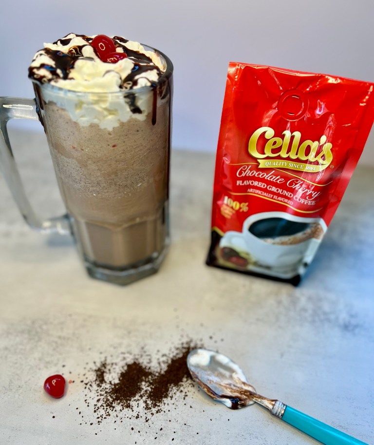 Chocolate Cherry Coffee Milkshake in a big mug with a bag of ground coffee next to it