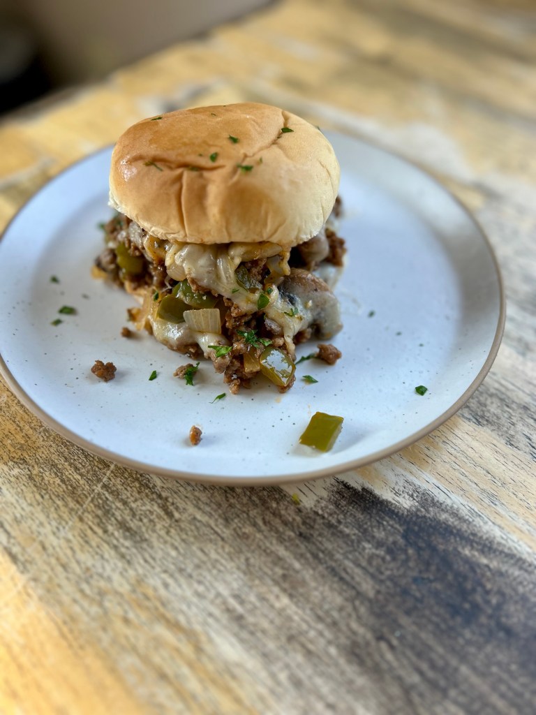 Mushroom Swiss Sloppy Joe on a bun on a white plate