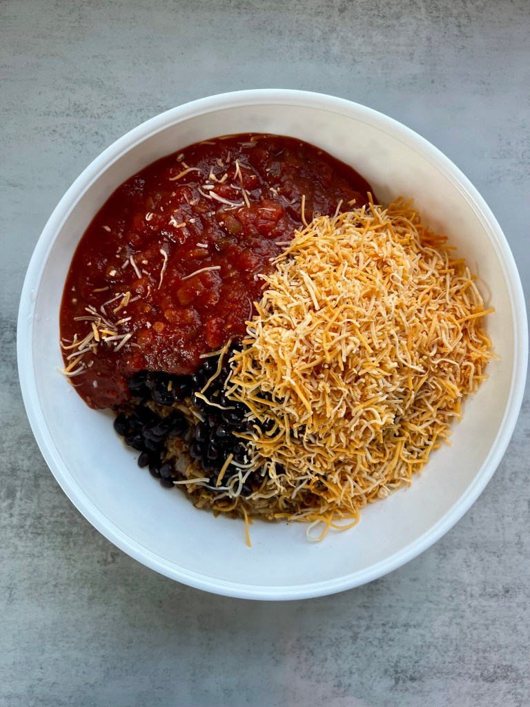 Filling ingredients for burrito bake in a large mixing bowl before being stirred