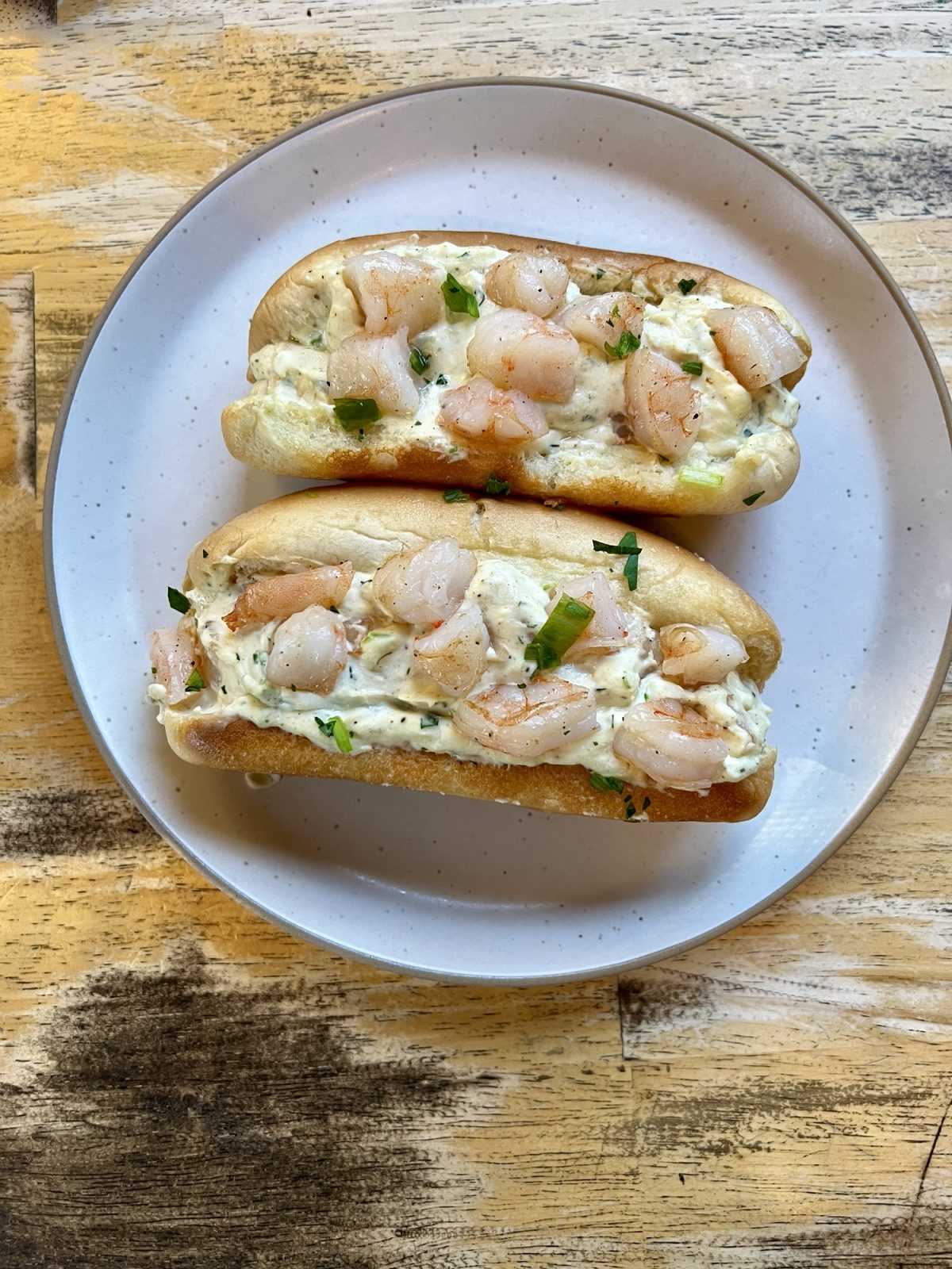 Shrimp rolls on a white plate on a wooden table