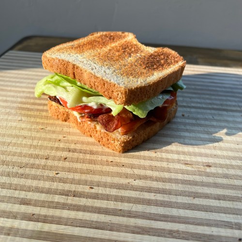 Ultimate BLT Sandwich on a wooden cutting board