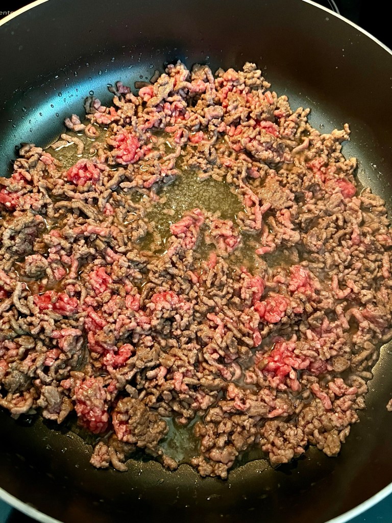 Ground beef cooking in a skillet on the stove