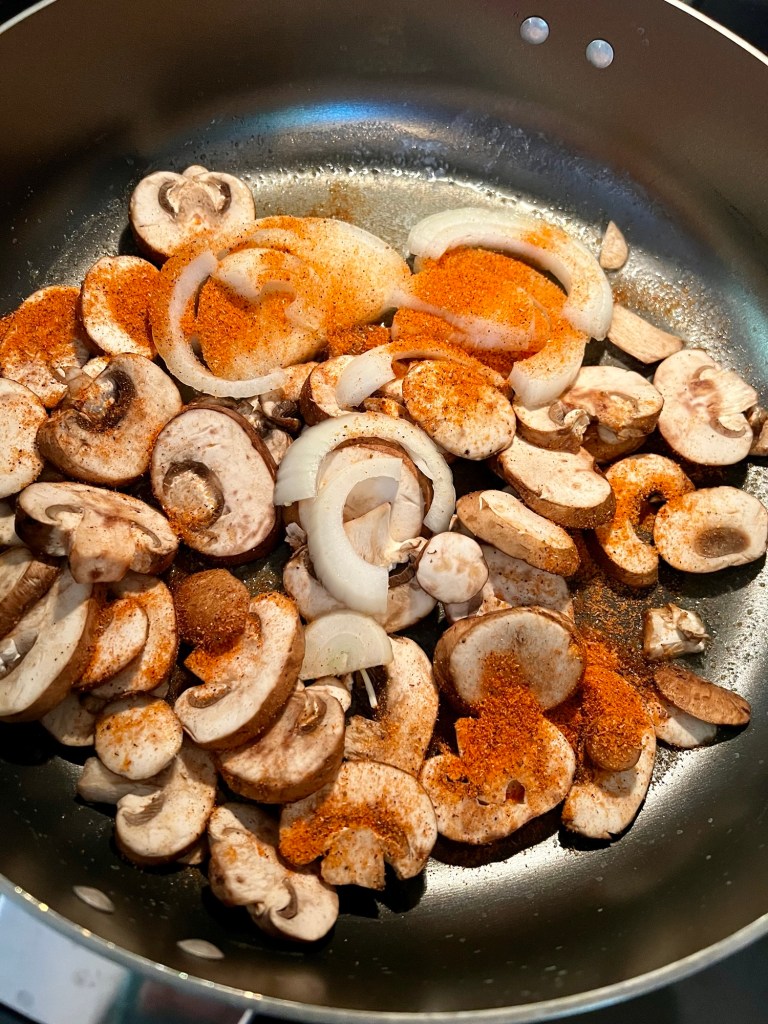 Mushroom, onion, butter, and steak seasoning in a large skillet on the stove