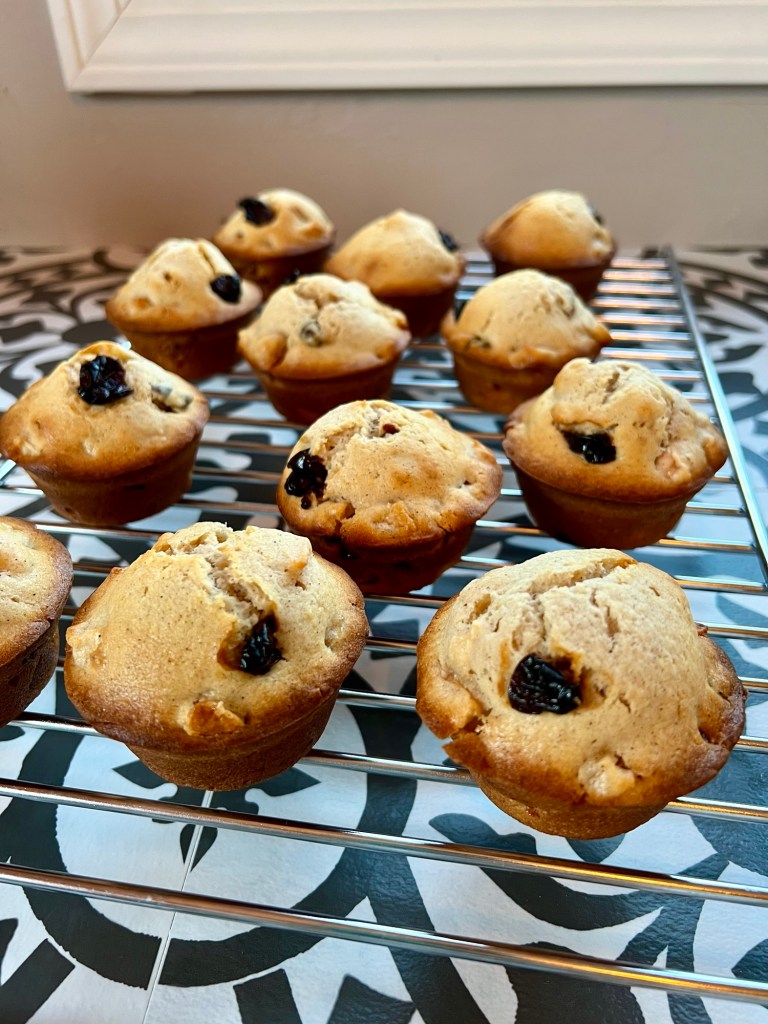 Apple cherry muffins on a cooling rack on a countertop