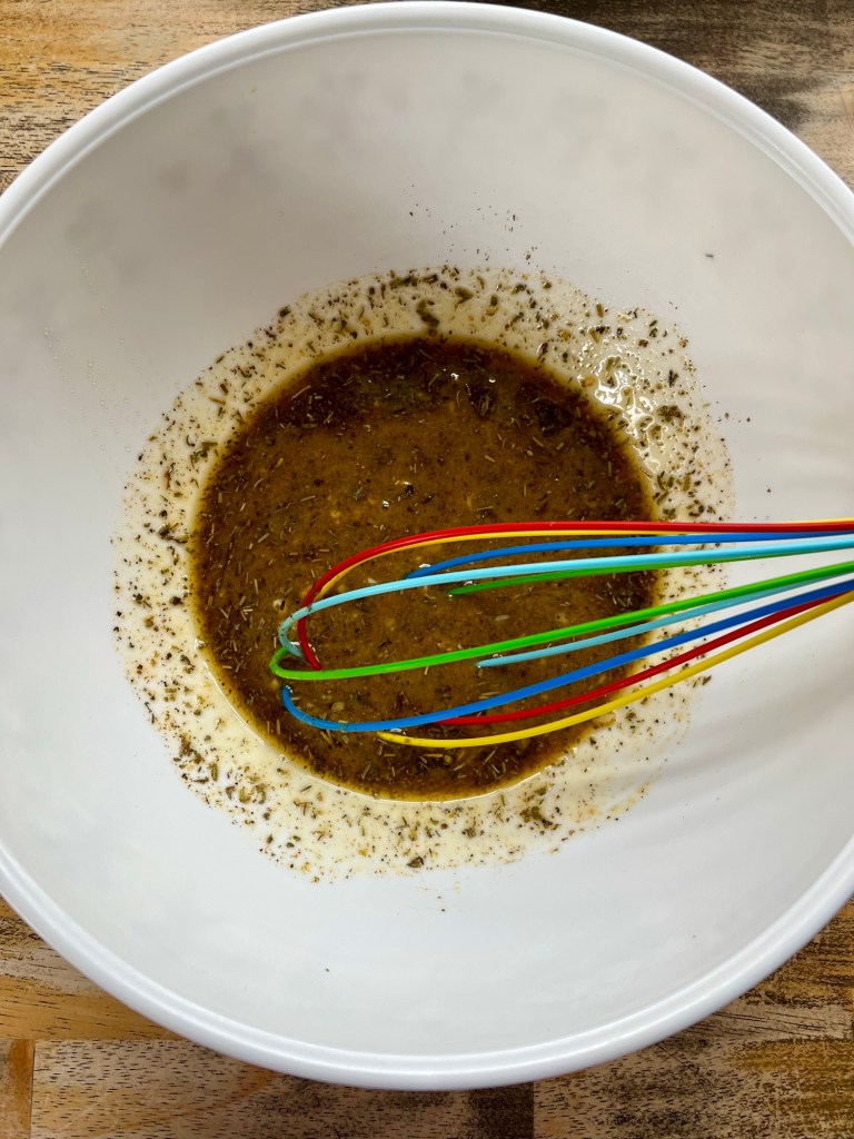 Honey Dijon marinade in a bowl with a whisk inside