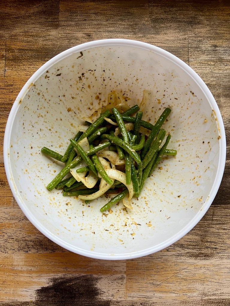 Beans and onions in a mixing bowl with honey dijon marinade