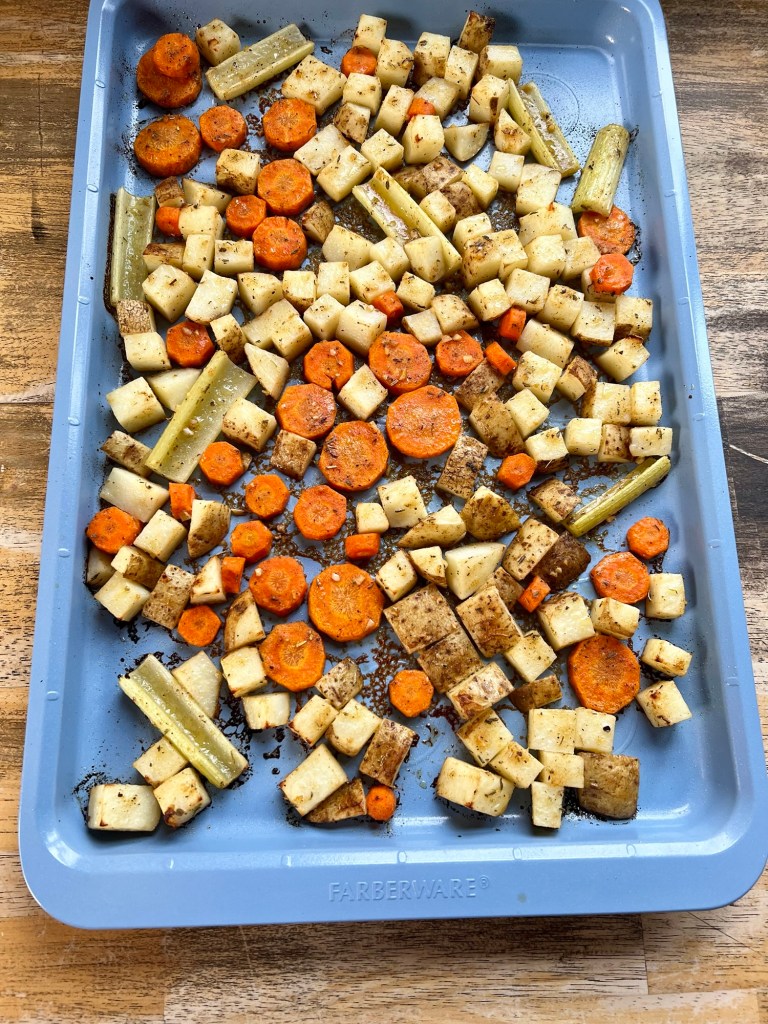 A baking sheet filled with carrots, celery, and potatoes