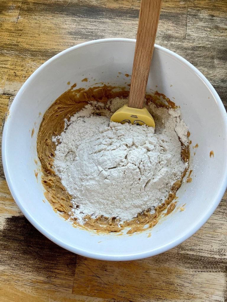 A large mixing bowl with cookie ingredients inside