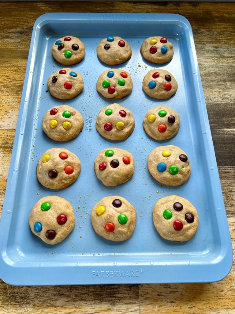 Peanut Butter M&M cookies on a blue baking sheet