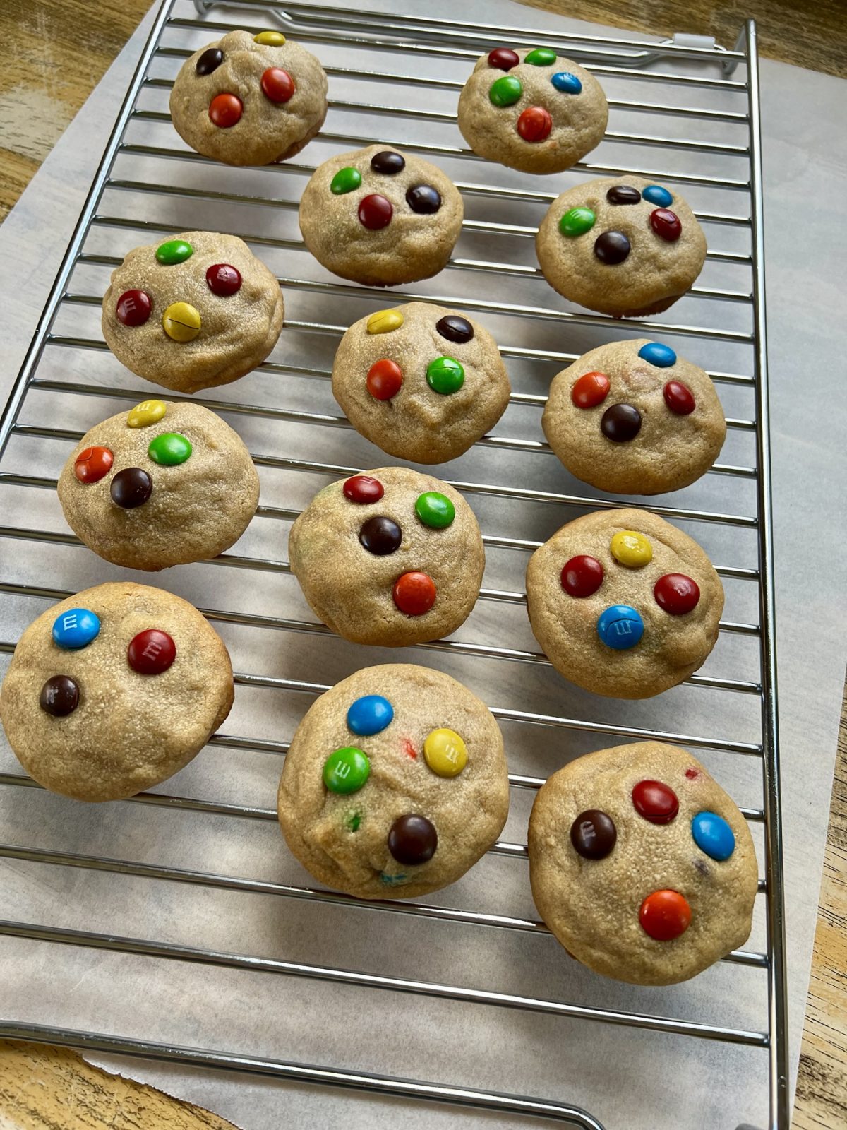 Peanut Butter M&M cookies on a cookie rack over some parchment paper