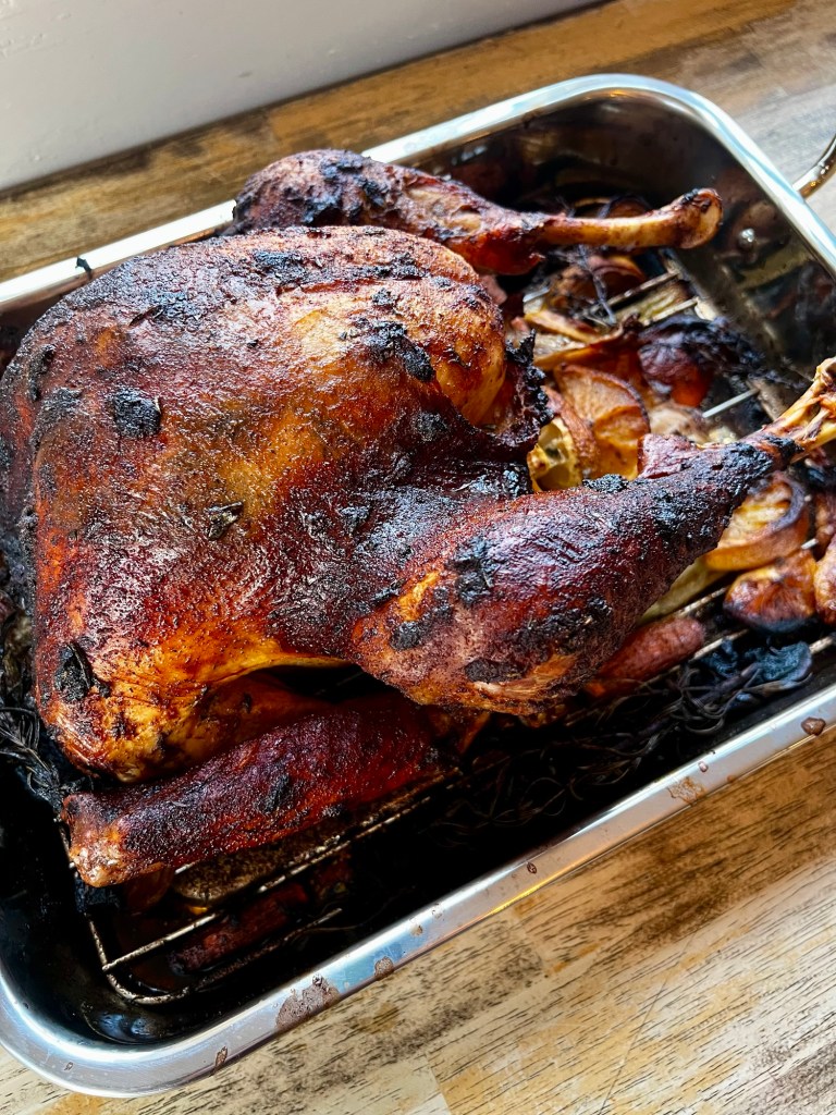 Garlic herb roasted turkey in a pan on a wooden table
