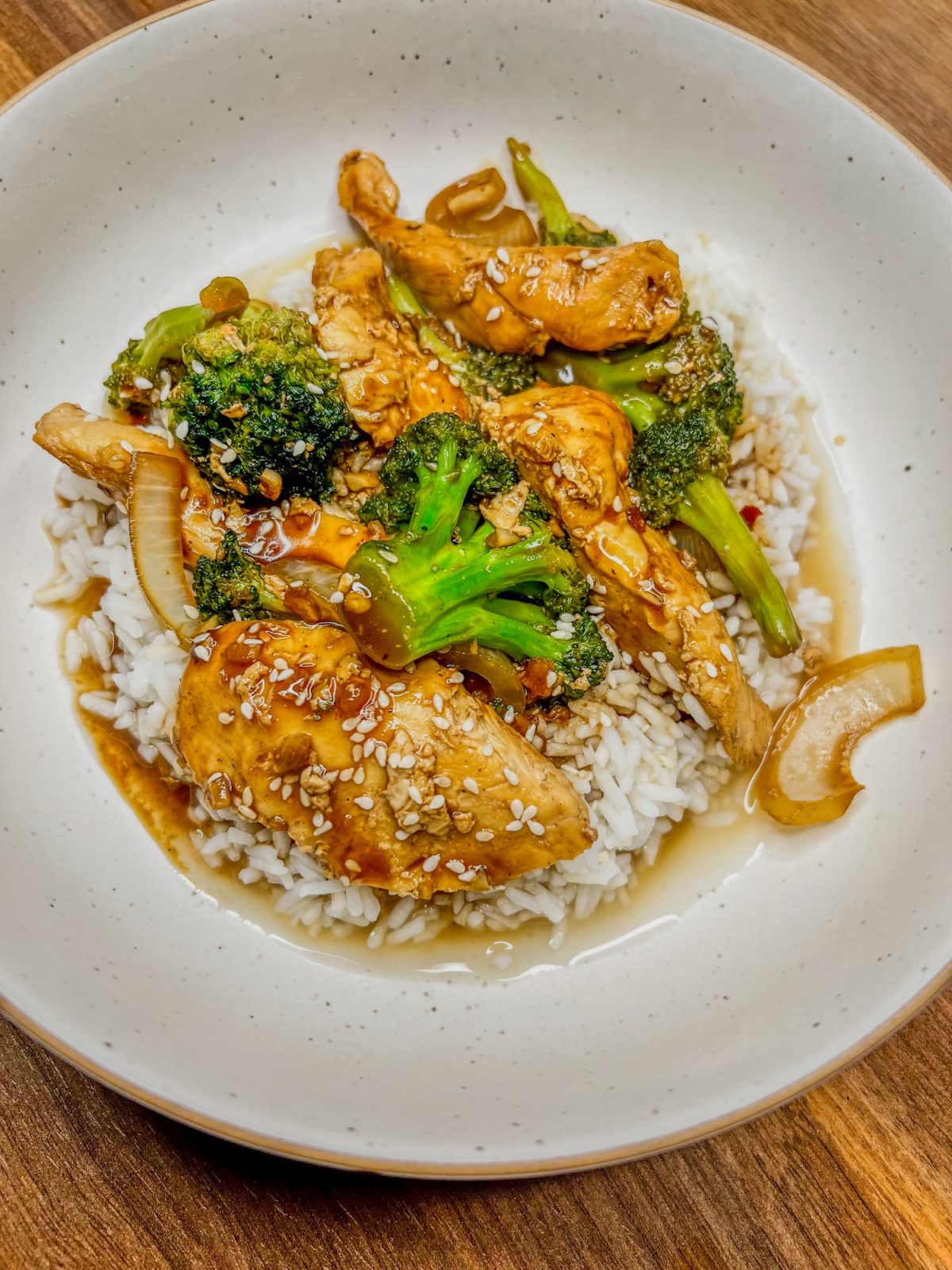 Chinese Chicken and Broccoli over some rice in a white bowl