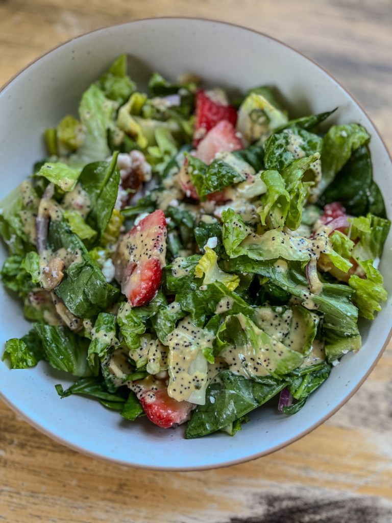 Strawberry Salad in a white bowl on a wood table