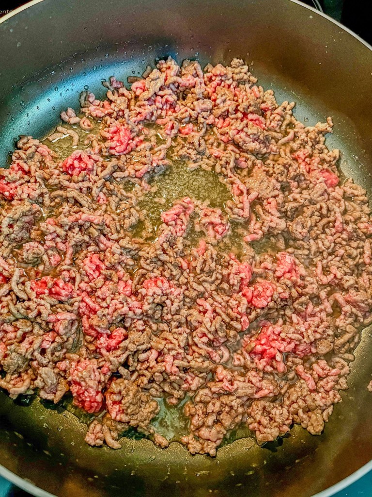 Ground beef cooking in a skillet on the stove
