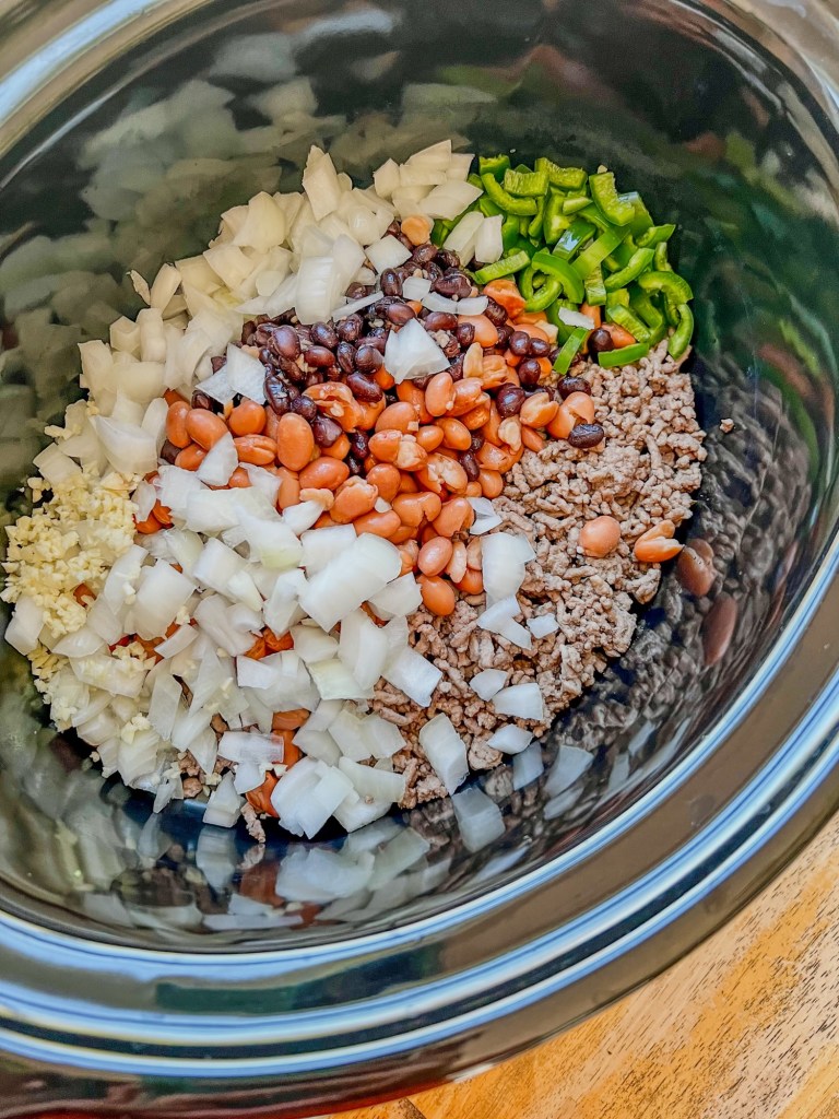 Large crockpot with beef and veggies inside before being cooked