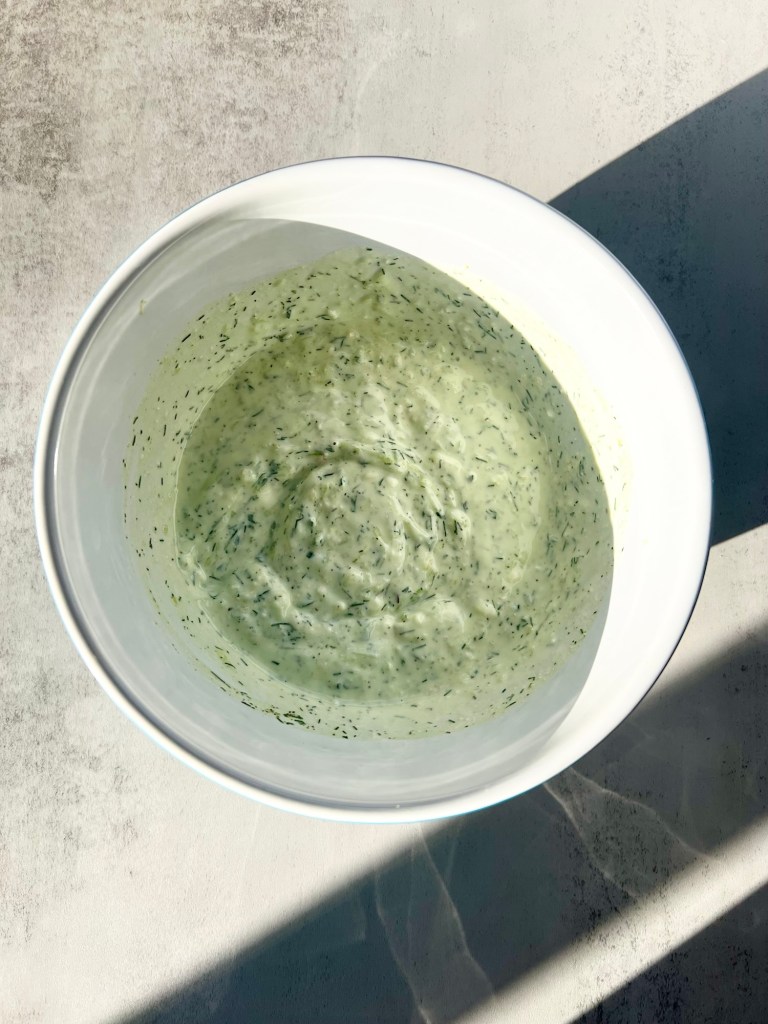 Freshly made tzatziki in a mixing bowl on a countertop