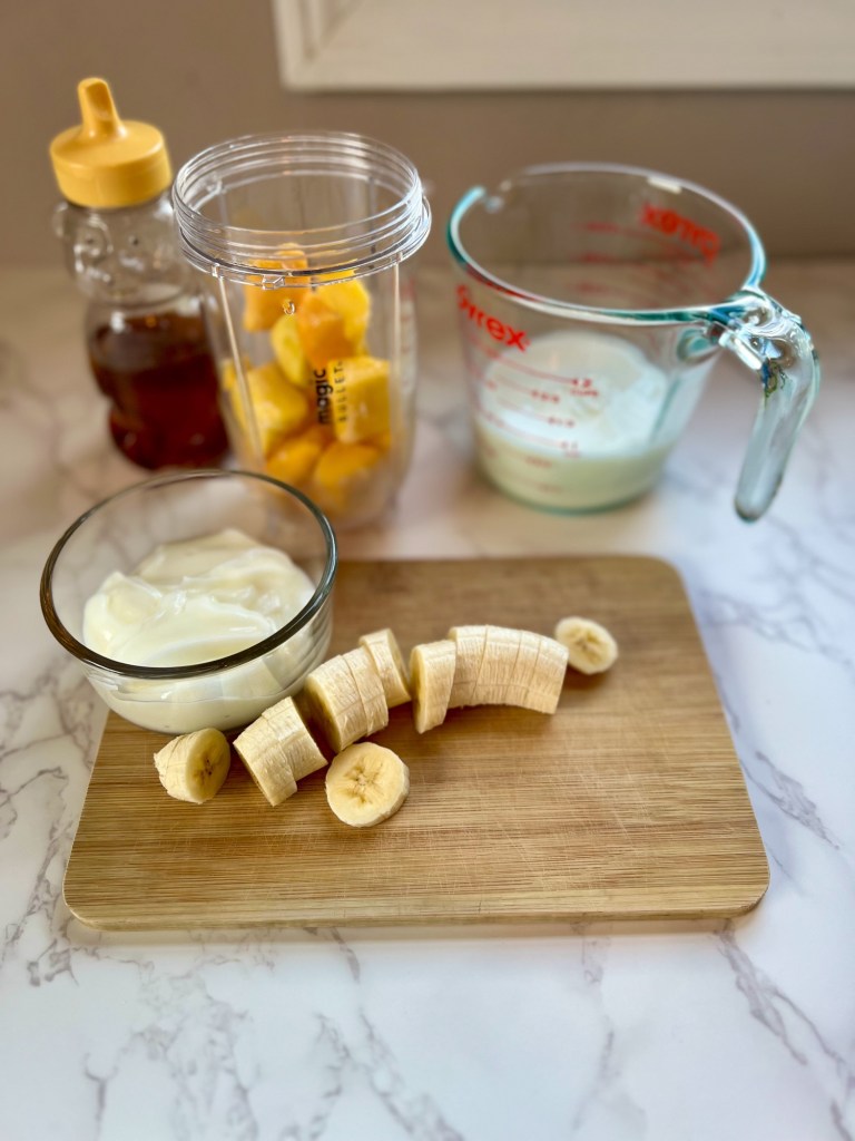 Ingredients for mango banana smoothie on a countertop