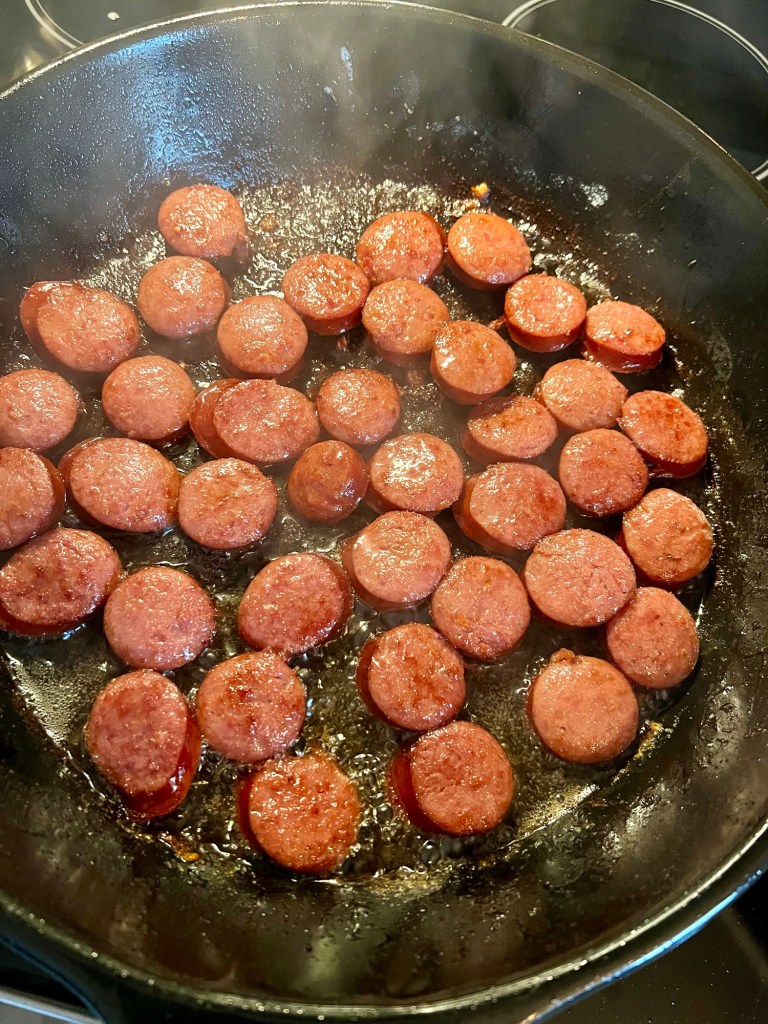 Sausage rounds cooking in an Xtrema pan on the stove