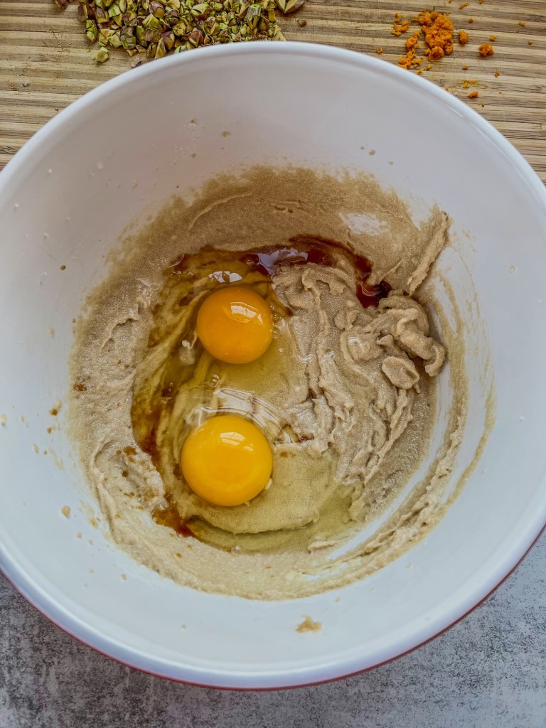 Wet ingredients for orange cranberry pistachio cookies in a mixing bowl