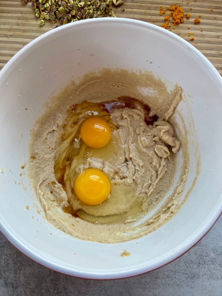 Wet ingredients for orange cranberry pistachio cookies in a mixing bowl