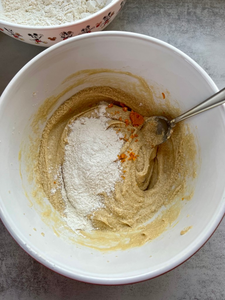 Wet and dry ingredients being mixed in a bowl for cookies