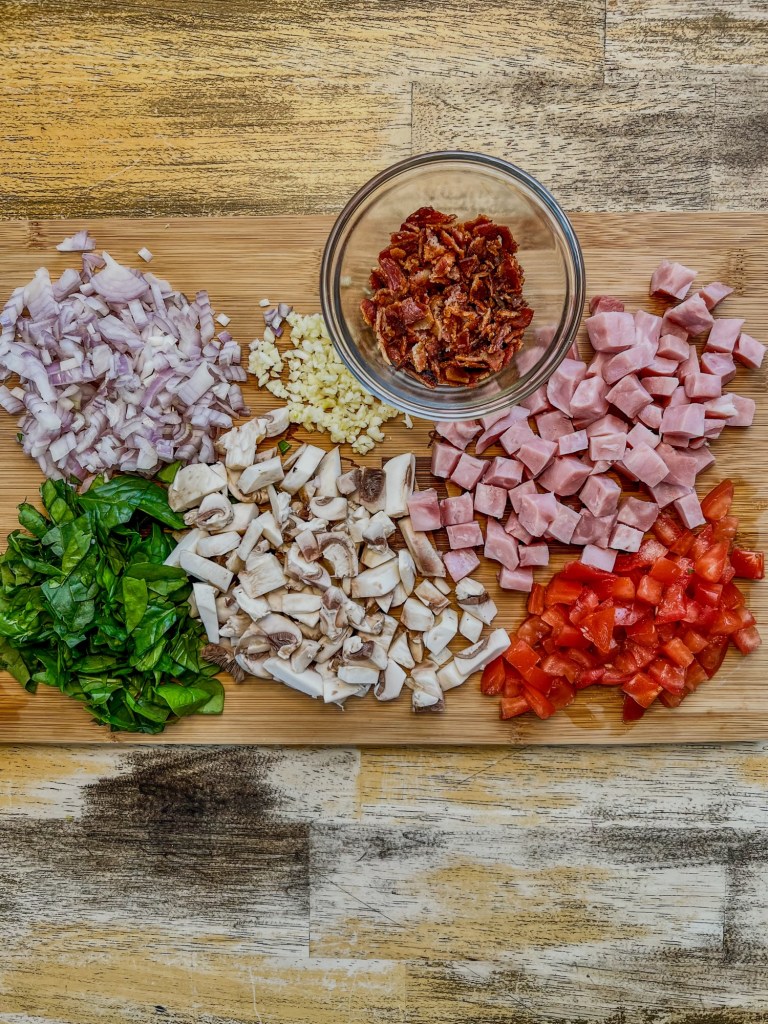Veggies to make omelets cut up on a wooden cutting board