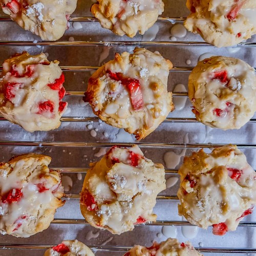 Strawberry scone cookies on a baking rack with parchment paper below