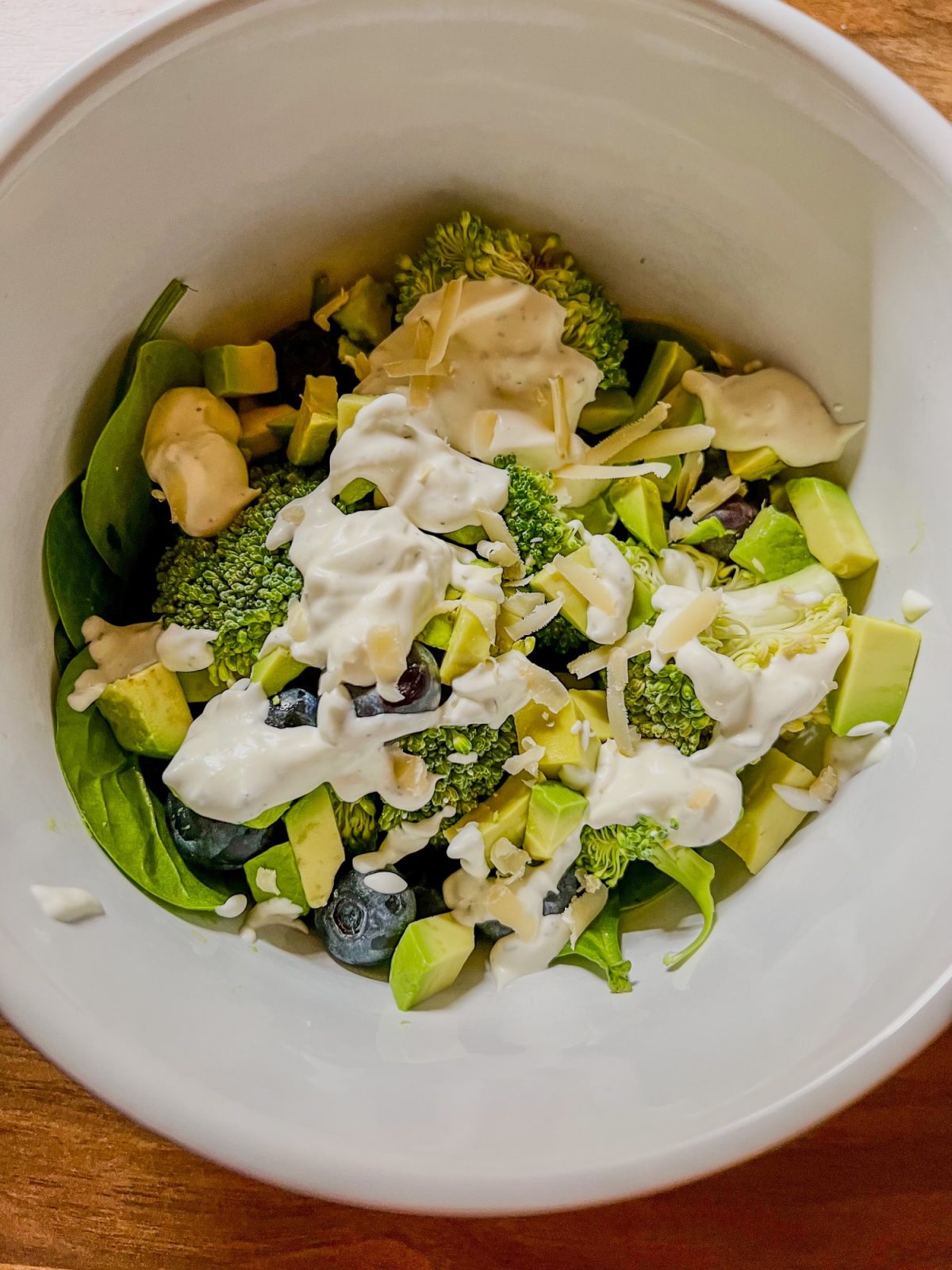 Avocado blueberry broccoli salad with creamy garlic dressing in a large bowl