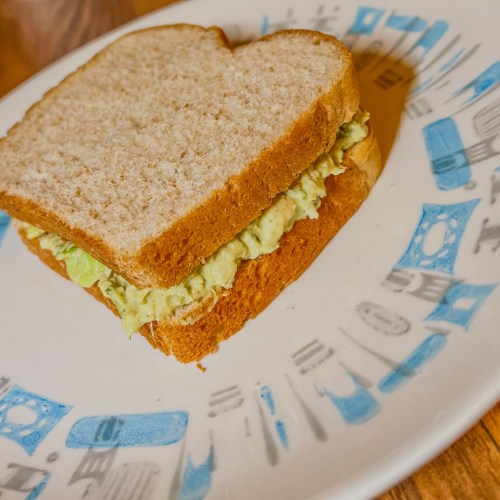 Avocado chicken salad on bread on a white plate