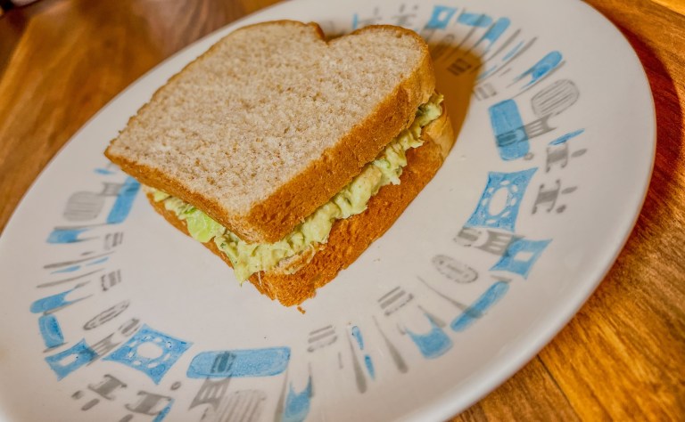 Avocado chicken salad on bread on a white plate