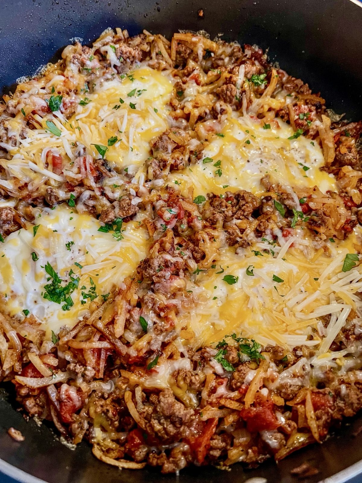 Cheesy beefy breakfast skillet in a large skillet on the stove