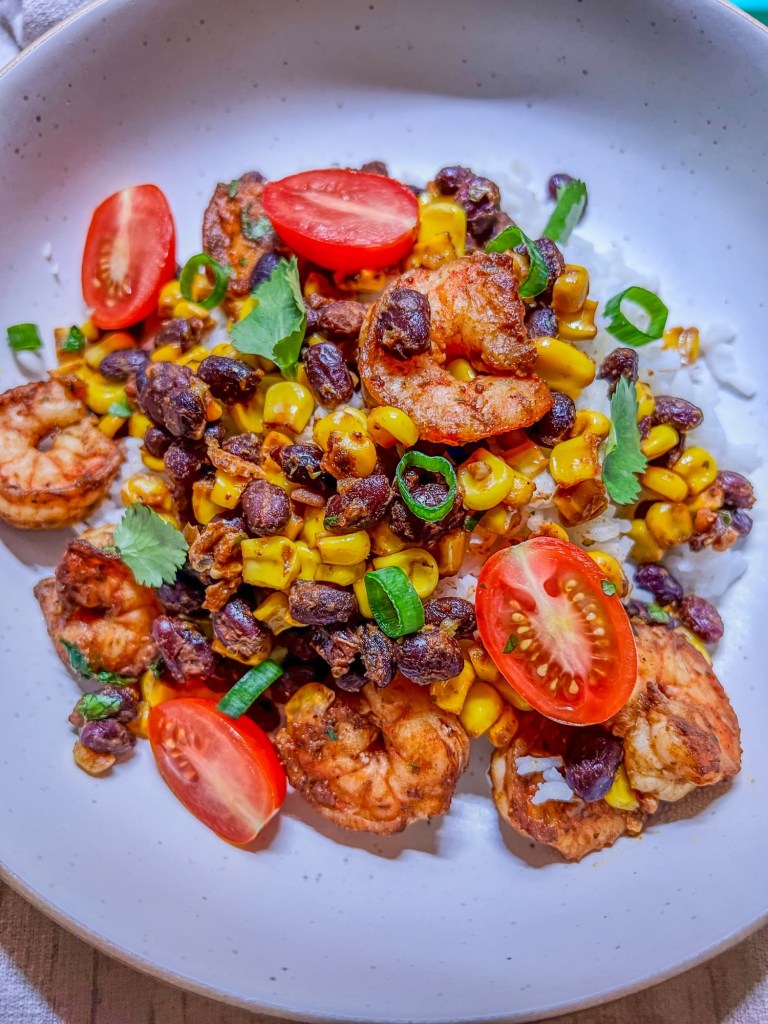Shrimp bowl over a bed of cilantro lime rice in a white bowl on a countertop